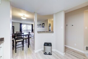 Eine moderne Wohnung mit Essbereich, Küche und Mülleimer.