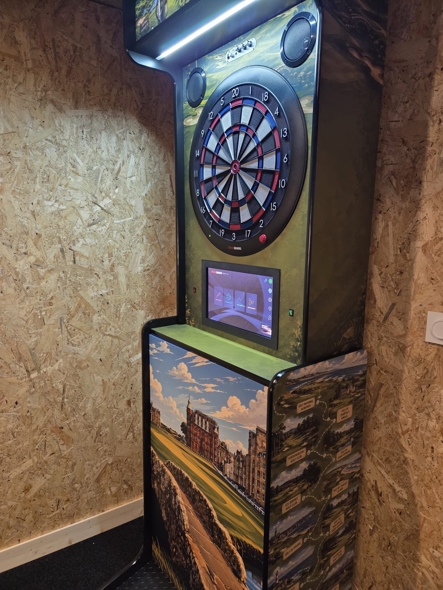 A dartboard mounted on a wall with a digital display below it.