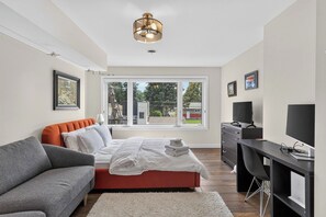 Ein modernes Schlafzimmer mit einem Bett, einem Schreibtisch und einer Couch.