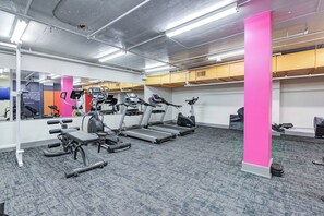 A gym with treadmills, elliptical machines, and weight benches. - Metro | Parking, Gym, Rooftop Patio (Saskatoon)