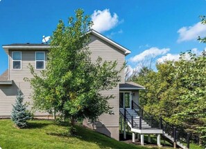A two-story house with a visible front porch and a satellite dish. - Luxury 6BR Retreat - Spacious & Refined Living (Apple Valley)