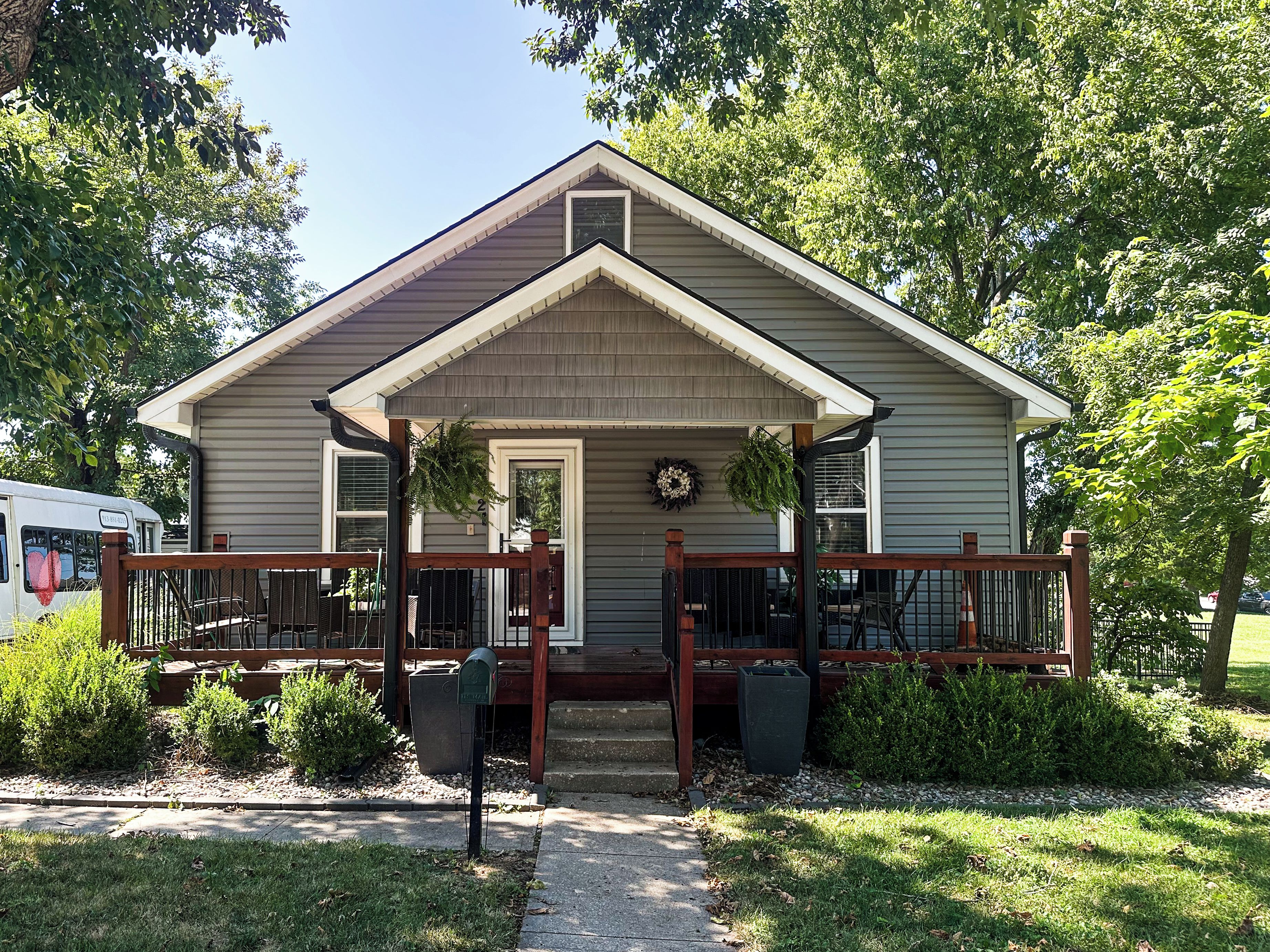 A single-story house with a front porch, a mailbox, and a small garden area.