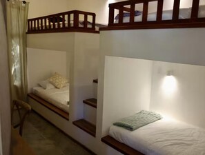 A room with bunk beds, a wooden ladder, and a single bed with a green blanket. - Casa Palmera: Brand-New 4BR Villa w/ Pool, 5-Min Walk to Beach (Nosara)