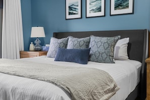 A neatly made bed with a grey and white patterned bedspread, a dark headboard, and multiple pillows in shades of grey and blue. - Lakeview Lodge | Hot Tub | Beach Access | Fire Pit (Invermere)