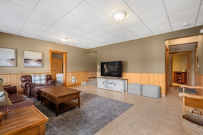 A spacious living room with a fireplace, a television, and a comfortable seating area. - Lakeview Lodge | Hot Tub | Beach Access | Fire Pit (Invermere)