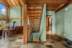A spacious interior with a wooden staircase, a sofa, and a lamp. - Lakeview Lodge | Hot Tub | Beach Access | Fire Pit (Invermere)