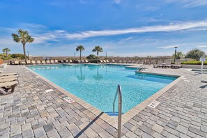 A swimming pool with lounge chairs and palm trees. - The Pelican Nest-Perfect North Myrtle Beach Getaway (MYRTLE BEACH)