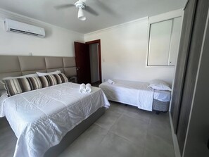 A hotel room with a large bed, a smaller bed, a ceiling fan, and an air conditioning unit. - CJ17GIL -3D -Arraial D’ajuda/Piscina/ Beach Tennis (Arraial da Ajuda)