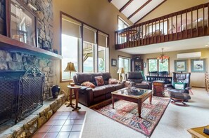 Sink into plush leather seating by the crackling stone fireplace in this warm, open living space. - Oversized 2 Bedroom Condo with Amazing Views from Two Balconies! (Sugar Mountain)