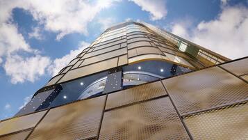 Een modern gebouw met een gebogen glazen gevel en een metalen vloer met een patroon.