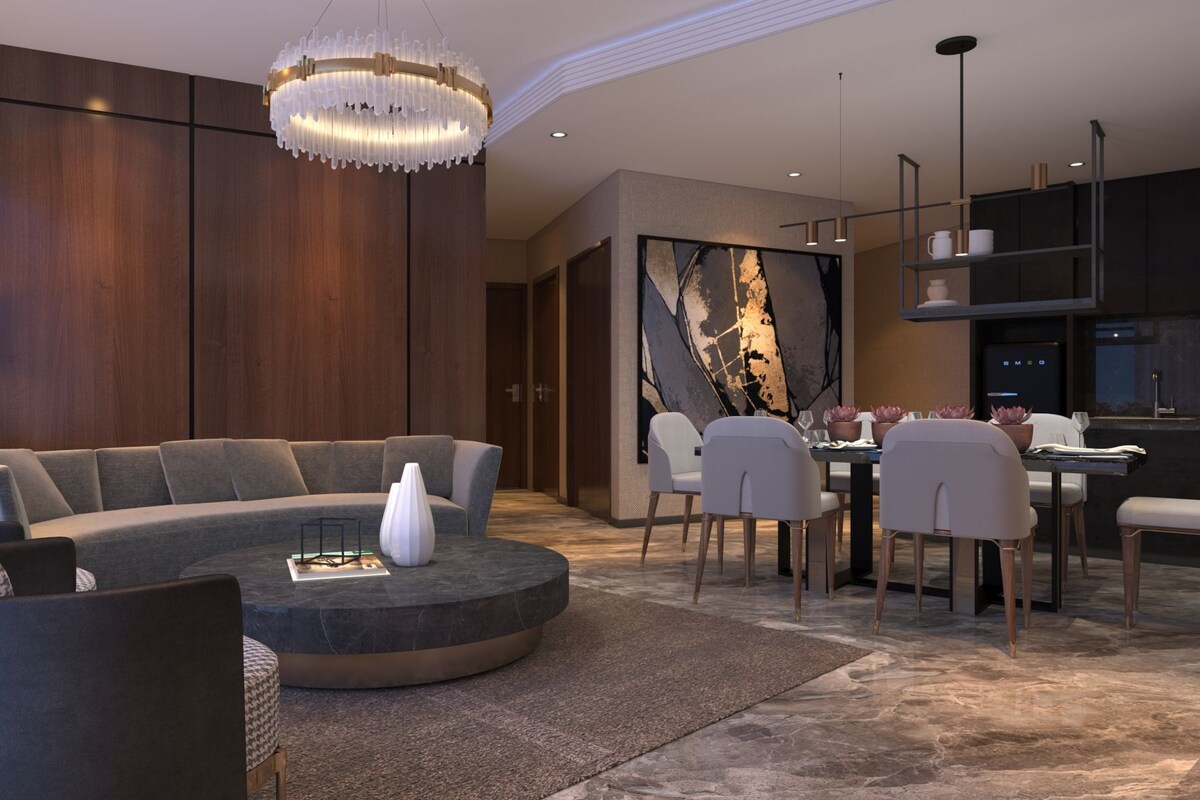 A modern living room with a sectional sofa, a round coffee table, and a dining area with a table and chairs.