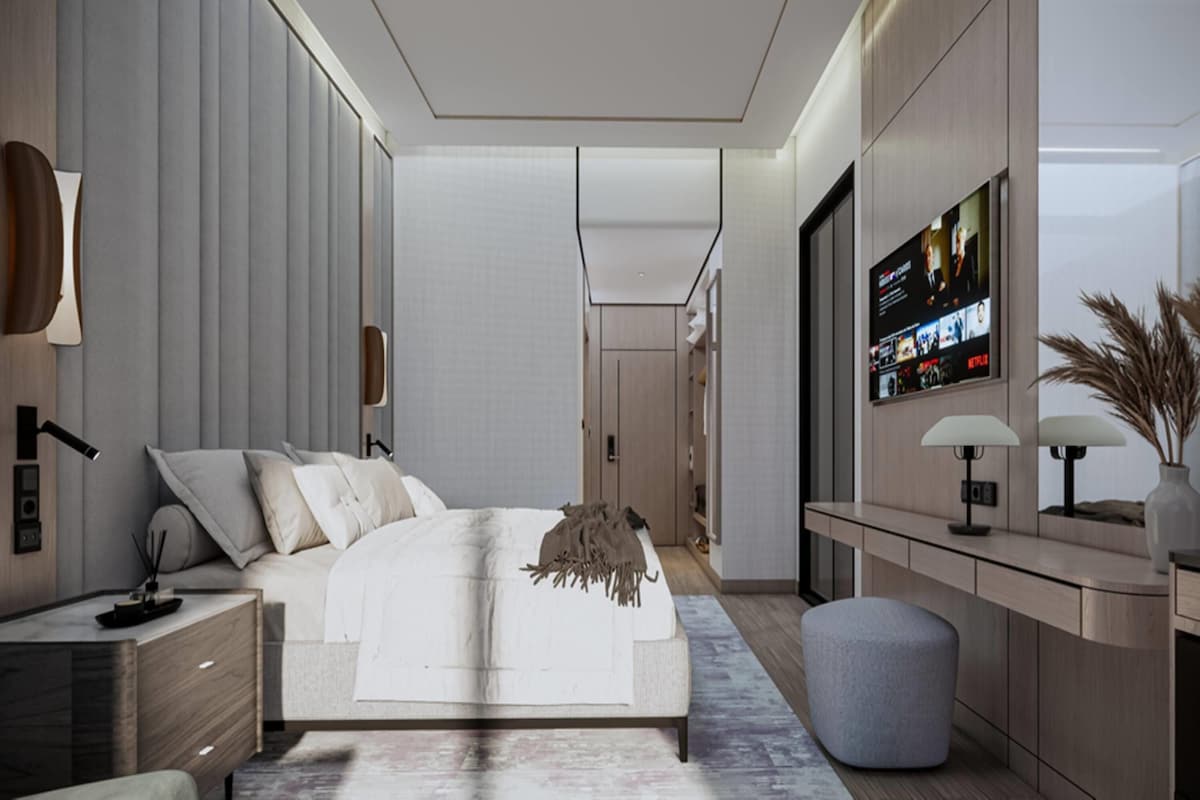 Un dormitorio moderno con una cama grande, mesitas de noche, un televisor y un escritorio.