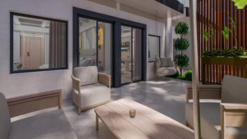 A modern outdoor living area with a sofa, chairs, a table, and a potted plant.