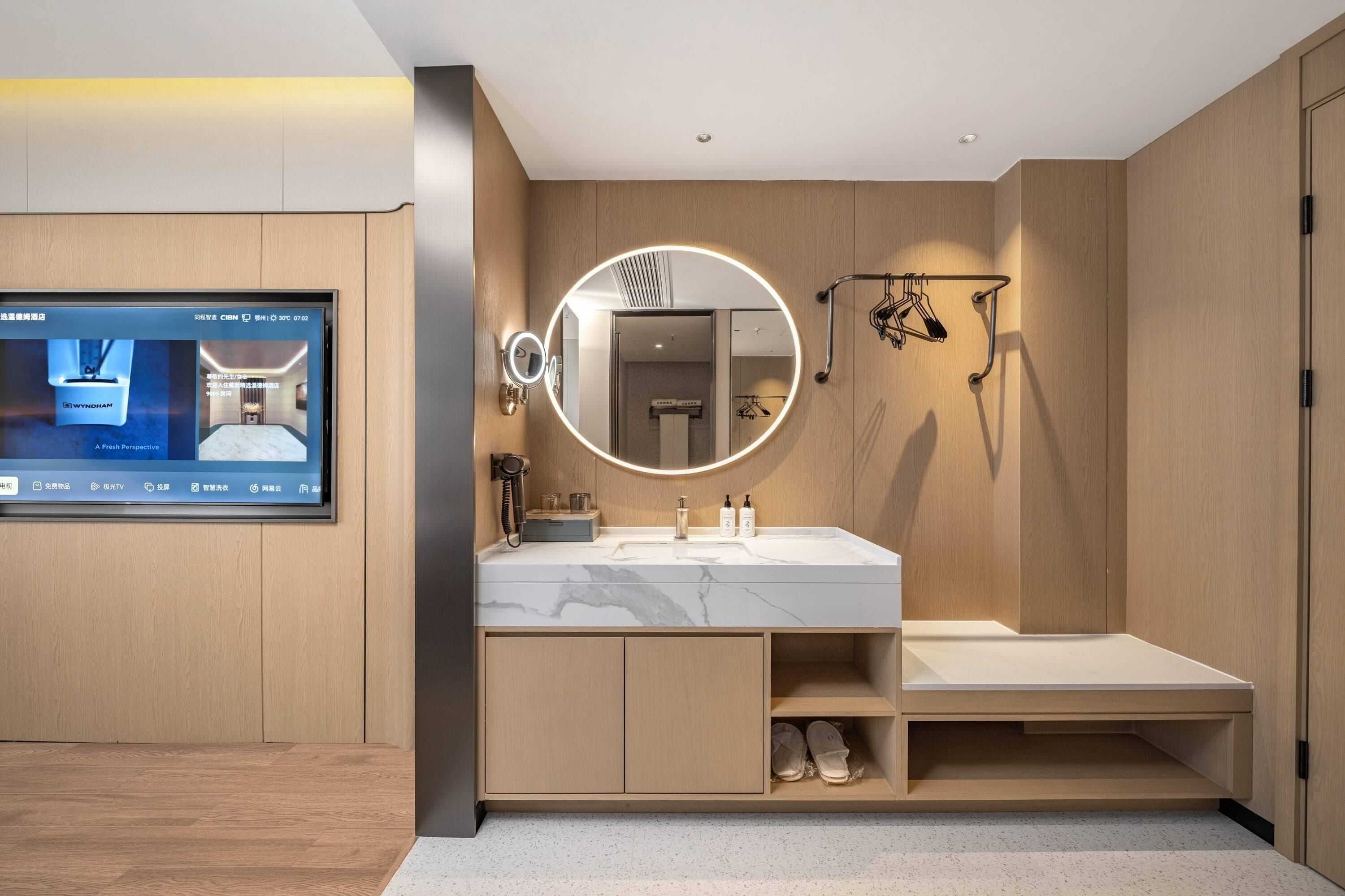 Un baño moderno con un espejo grande, un tocador con lavamanos y una zona de ducha.