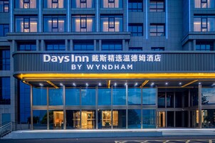 A hotel entrance with a large sign reading 'Days Inn BY WYNDHAM' and a modern architectural design.