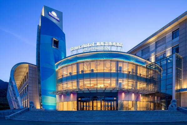 A Days Hotel by Wyndham with a modern glass facade and a prominent sign.
