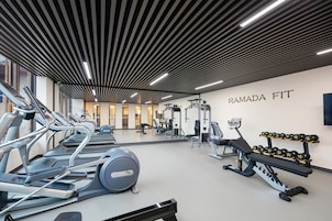 Un gimnasio moderno con cintas de correr, máquinas de pesas y mancuernas.