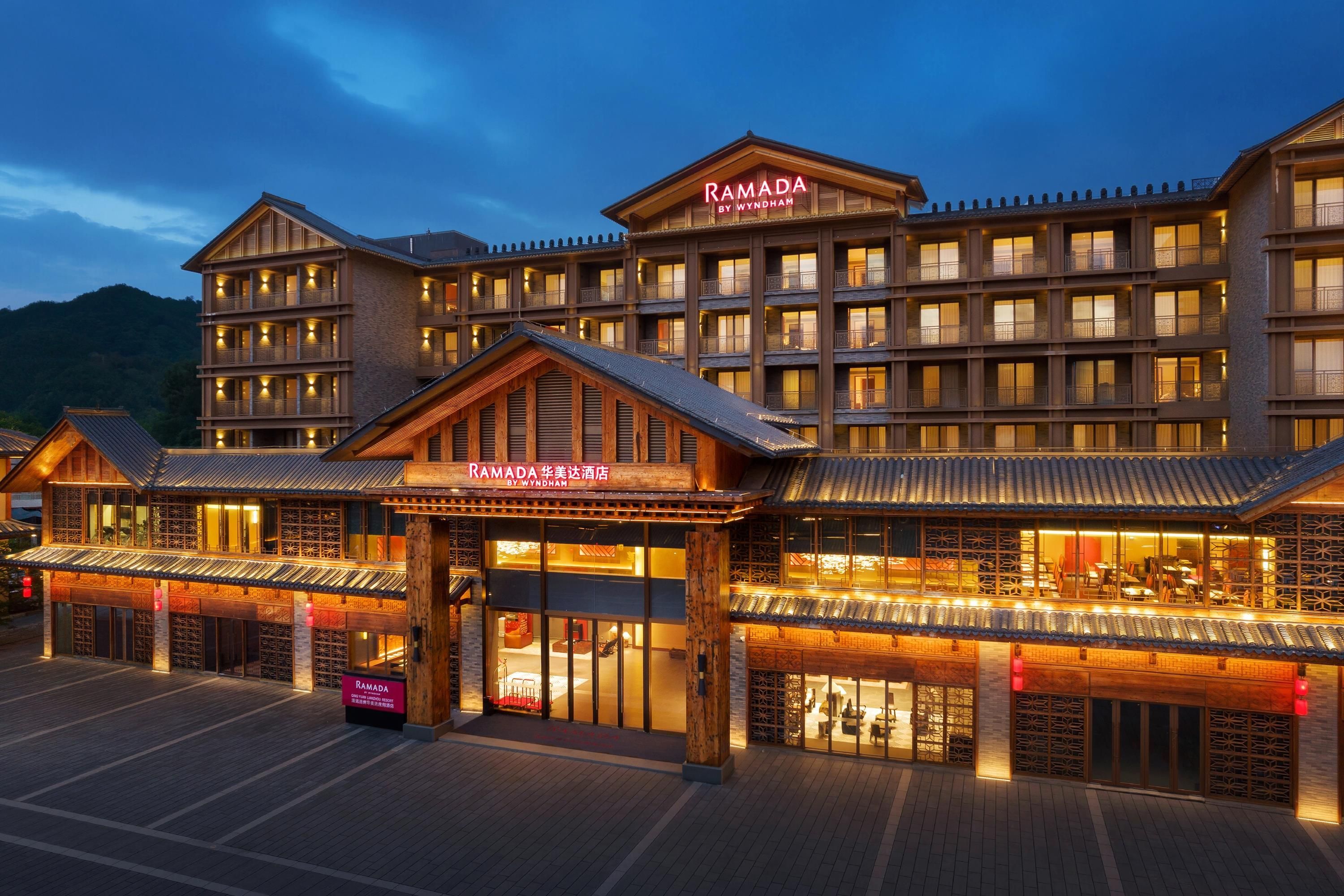 A multi-story hotel with a traditional architectural style, featuring a prominent entrance with a sign.