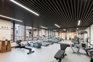 A modern gym with treadmills, elliptical machines, and weight equipment.