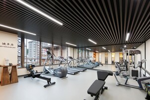 Un gimnasio moderno con cintas de correr, elípticas y equipo de pesas.