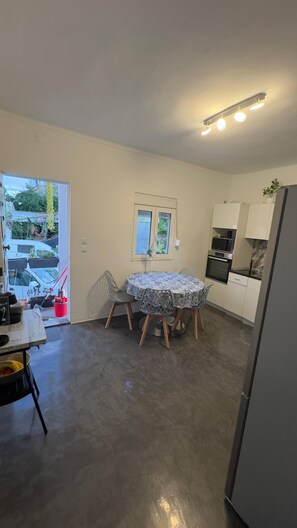 A compact kitchen with a dining table, a refrigerator, and a microwave. - Room-serene Condo Retreat in Vimieiro, P (Santa Comba Dao)