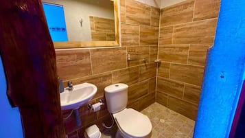 A bathroom with a sink, toilet, and shower.
