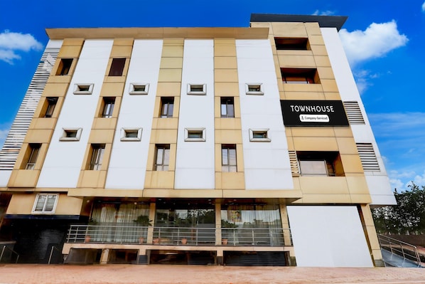 A multi-story building with a sign reading 'TOWNHOUSE' and 'Company-Serviced.'