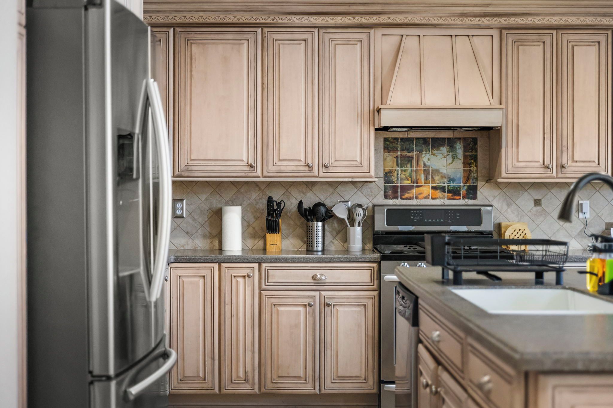 Warm gourmet kitchen with island, stainless appliances, and custom cabinetry