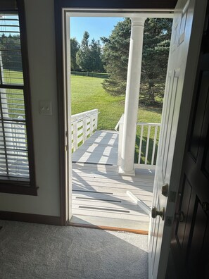 A view from a room to an outdoor deck with a white railing and a column. - Round Hill Retreat-One Bedroom Apartment - Handicap Accessible (Round Hill)