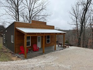 A small cabin with a porch, a red chair, and a picnic table. - The Rock-N-Roll Cabin with Meramec River Access (Liberty Township)