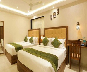 A hotel room with two beds, a desk, and a chair. - Collection O Chena Creek Godbandar (Mumbai)