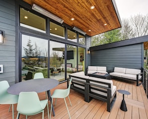An outdoor deck with a dining area, seating, and a view of the surrounding landscape.