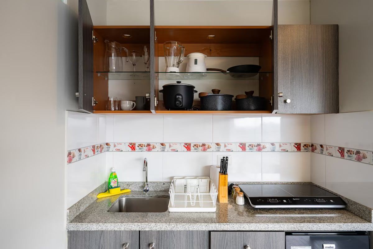 Una cocina con encimera de granito, lavavajillas integrado y microondas.
