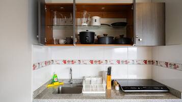 Una cocina con encimera de granito, lavavajillas integrado y microondas.