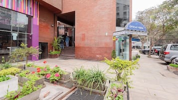 Un edificio con fachada de ladrillo, entrada de vidrio y un letrero que dice 'OPTICAS VIENA'.