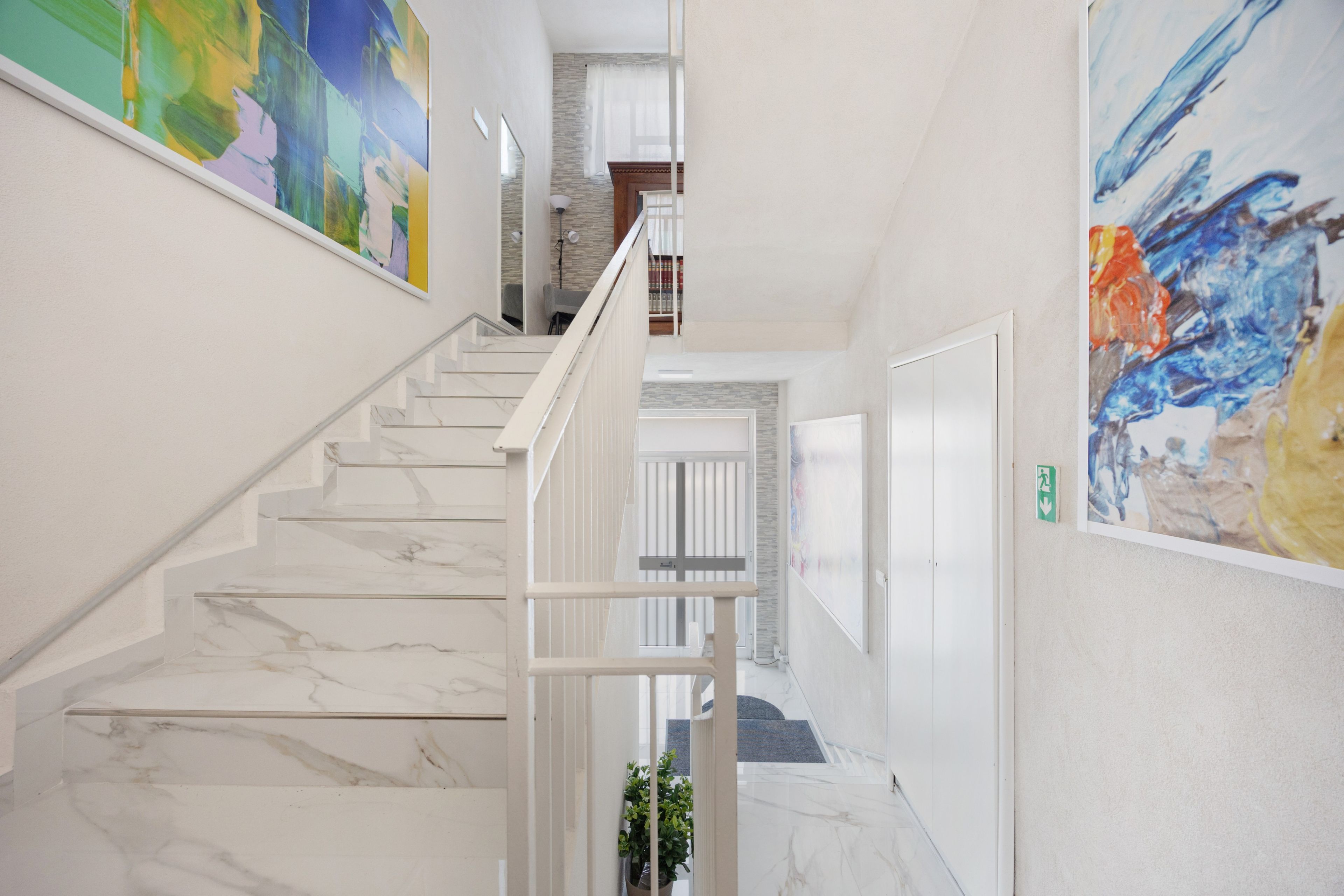 A staircase with marble steps leading to a landing with a view of a room.