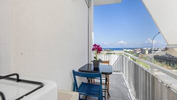 Un balcone con tavolo, sedie e una pianta in vaso.