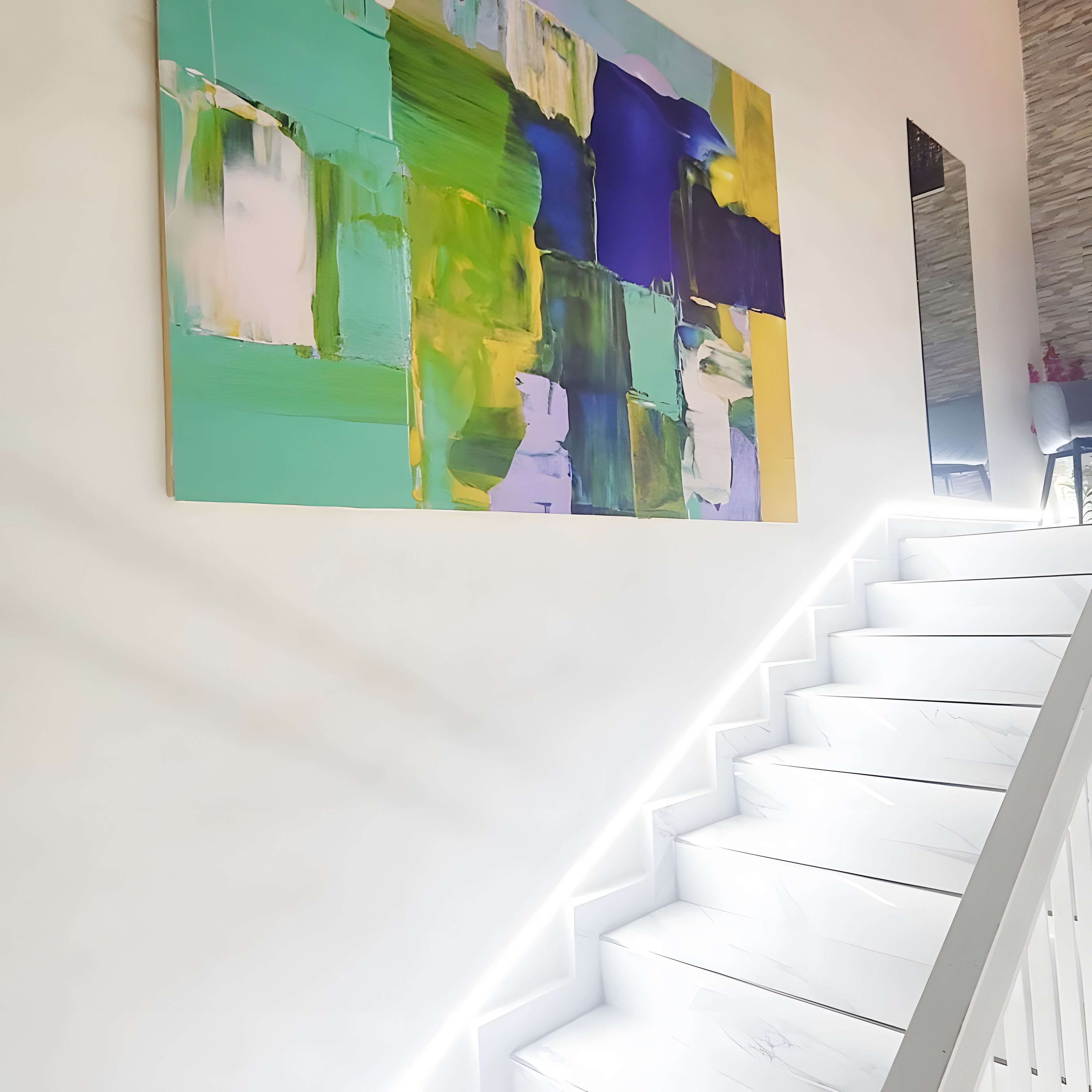 Uma escadaria com degraus brancos leva a um patamar onde está exposta uma pintura abstrata e colorida.