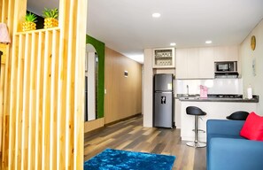 A modern kitchen with a refrigerator, microwave, and bar stools. - "Modern Apartment in Sabaneta with a Panoramic View" (Sabaneta)