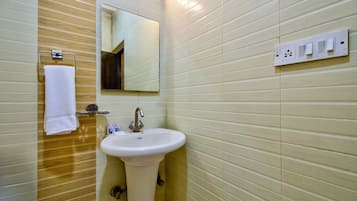 Une salle de bain équipée d’un lavabo, d’un miroir, d’un porte-serviettes et de prises électriques au mur.