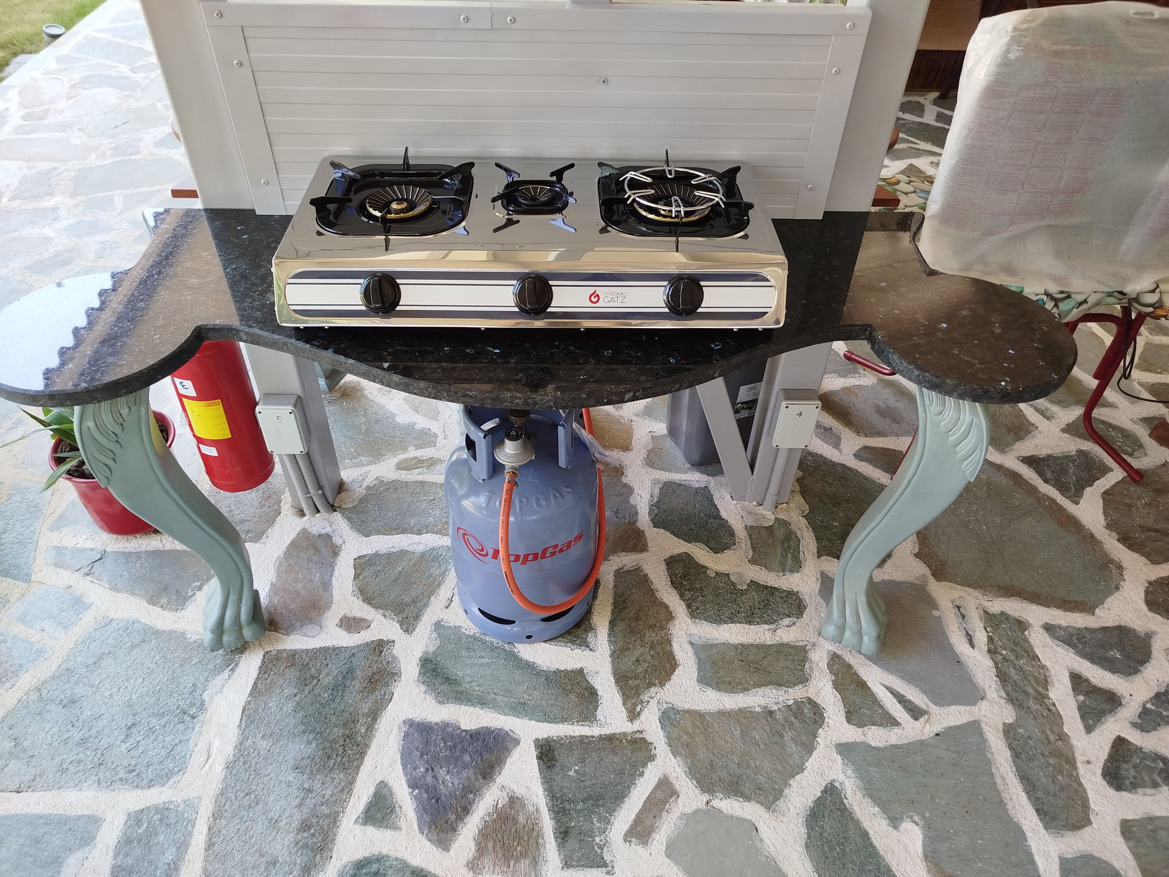 Un fornello a gas con due fuochi e una bombola di gas sottostante.