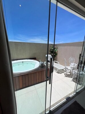A balcony with a hot tub, outdoor furniture, and a clear view of the sky. - Pousada Arraial Tropical (Arraial do Cabo)