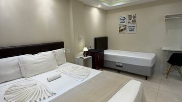 A hotel room with a large bed, bedside tables, a desk, and a chair.
