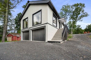 A modern two-story house with a garage, a staircase, and a gravel driveway. - Twin Pines Retreat & Lodge (Catskill)