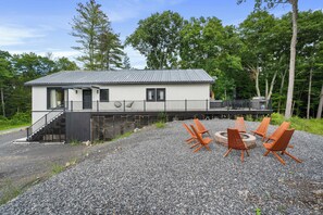 A single-story building with a porch, outdoor seating, and a gravel driveway. - Twin Pines Retreat & Lodge (Catskill)