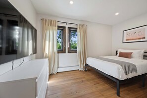 A bedroom with a bed, a desk, and a window with curtains. - Twin Pines Retreat & Lodge (Catskill)