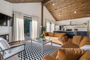 A modern living room with a sofa, coffee table, and a fireplace. - Twin Pines Retreat & Lodge (Catskill)