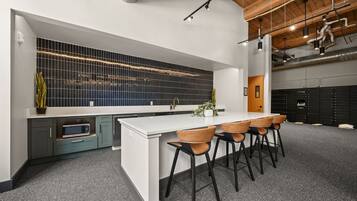A modern kitchen with a white island, bar stools, and a backsplash with a grid pattern.