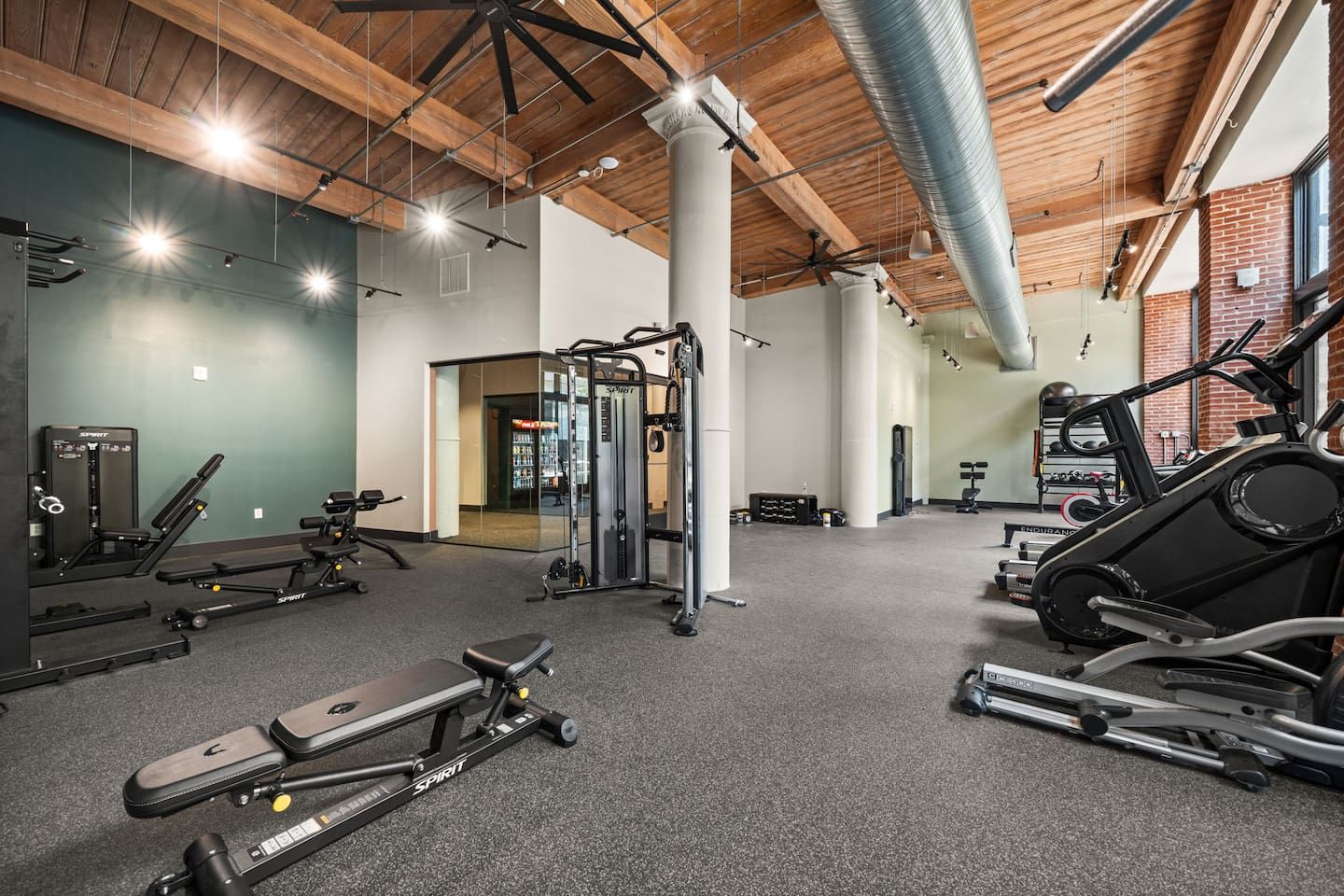 A gym with various exercise equipment, including a treadmill, weight machines, and a squat rack.