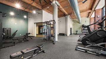 A gym with various exercise equipment, including a treadmill, weight machines, and a squat rack.